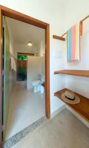 a bathroom with a toilet and a sink at Jardim Cumuru - Suítes in Cumuruxatiba
