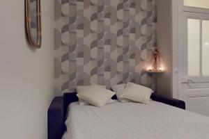 ein Schlafzimmer mit einem Bett und zwei Kissen darauf in der Unterkunft Le Cocon dans les Nuages in Villeurbanne