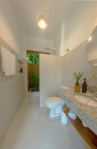 a bathroom with a toilet and a sink at Jardim Cumuru - Suítes in Cumuruxatiba +17 photos