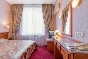una stanza d'albergo con un letto e uno specchio di Ukraine Hotel a Kiev Altre 72 foto