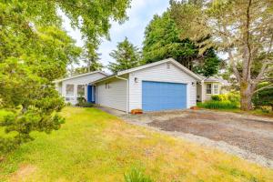 a house with a blue garage in a yard at Walk to Seaside Beach Vacation Rental Cottage! in Seaside
