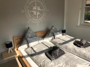 two beds in a room with a clock on the wall at "Tag am Meer" - Residenz Glücksmomente EG in Langeoog