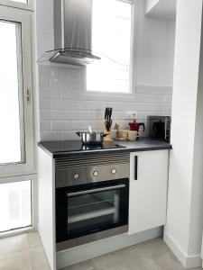 a kitchen with a stove and a sink and a window at AT Paseo Ficus Centenario in Almería +11 photos