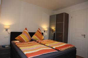 Bett mit bunten Kissen auf einem Zimmer in der Unterkunft Villa Poseidon by Rujana in Binz