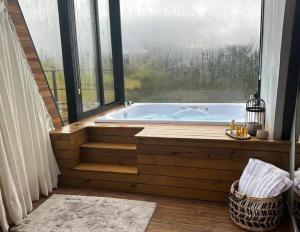 a bath tub in a room with a large window at Cabana Alecrim in Itanhandu