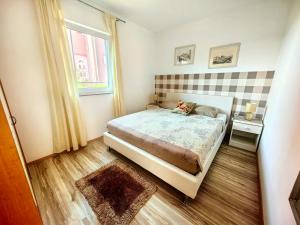 a small bedroom with a bed and a window at Apartments Lea with pool 2 in Malinska +31 photos