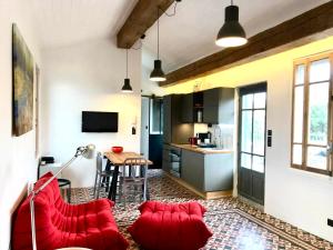 a living room with red couches and a kitchen at Le Rooftop Collioure in Collioure
