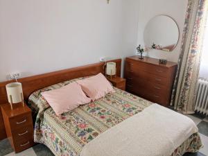 a bedroom with a bed and a dresser and a mirror at Ático en Toro - Parque de La Golosina in Toro