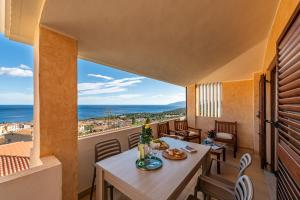 a balcony with a table and chairs and a view of the ocean at Casa Marco Sardinia Domus in Cala Gonone