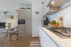 Una cocina con encimeras blancas y una mesa con una cesta de verduras. en Pisa AirPort-Train Station AC Free Parking, en Pisa