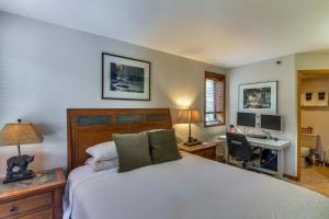Un dormitorio con una cama y un escritorio con una computadora. en Cozy Ski-InandSki-Out Winter Park Condo with Pool!, en Winter Park 29 fotos más