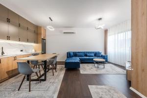 a living room with a blue couch and a table at The City Center Penthouse by PS in Durrës
