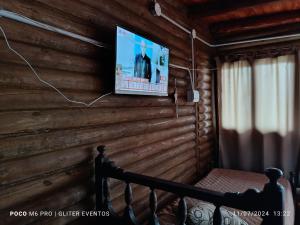 Un televisor en una pared de madera en una habitación. en Amphu, en La Falda