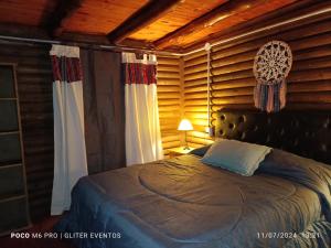 Un dormitorio con una cama en una habitación con paredes de madera. en Amphu, en La Falda 19 fotos más