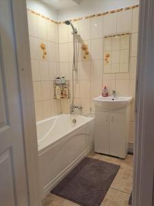 a bathroom with a tub and a sink at Sunny flat 250m from the beach in Liepāja +10 photos