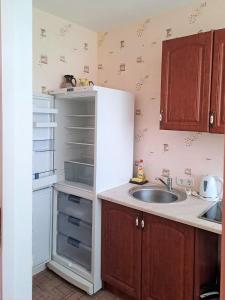 a kitchen with a sink and a white refrigerator at Sunny flat 250m from the beach in Liepāja