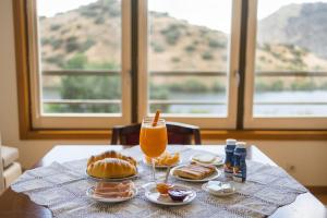 a table with a plate of food and a glass of orange juice at Olhares do Douro in Torre de Moncorvo
