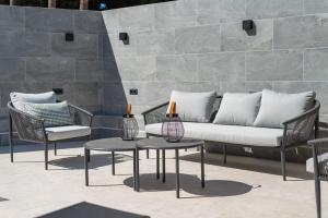 un patio con sofá y 2 mesas y sillas en Casa Sicilia, en Puerto Rico de Gran Canaria