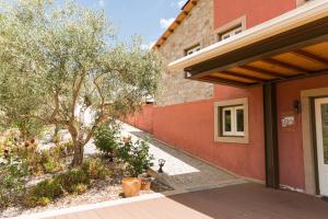 an entrance to a house with a tree and a building at Olhares do Douro in Torre de Moncorvo