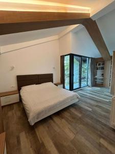 a bedroom with a bed and a large window at Luxury Villa Silvija Mavrovo in Mavrovo