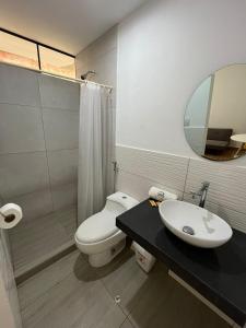 ein Badezimmer mit Toilette, Waschbecken und Spiegel in der Unterkunft Casa de Anita 03 in Malabrigo