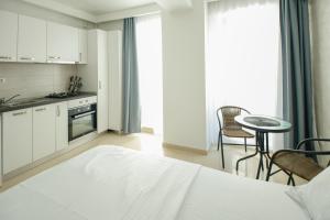 a bedroom with a bed and a table and a kitchen at Studio Deluxe Astoria Lake in Năvodari