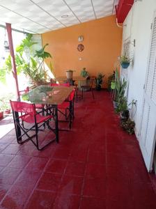 a room with tables and chairs and a red tile floor at Sandy in Cordoba