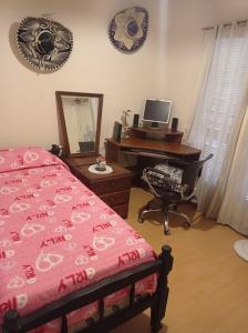 a bedroom with a bed and a desk with a computer at Sandy in Cordoba