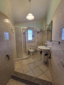 un bagno con lavandino, WC e doccia di B&B Il Girasole a SantʼAnna Arresi