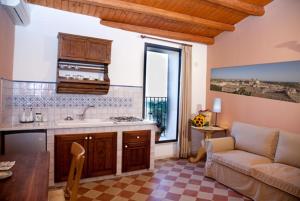 a kitchen and living room with a couch and a table at Carruggiu Casavacanze in Caltagirone