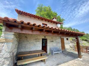 a stone house with a bench on a patio at Casa da iapa in Soajo
