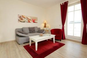ein Wohnzimmer mit einem Sofa und einem Tisch in der Unterkunft Haus & Villa Seydlitz by Rujana in Binz