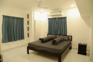 a bedroom with a bed with green curtains at F-1 Tulsi By The Peace in Chennai
