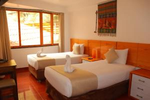 una camera d'albergo con due letti e una finestra di Fenix Hotel Machupicchu a Machu Picchu