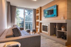 ein Wohnzimmer mit Couch und Kamin in der Unterkunft Rosa Edifício Bav in Gramado