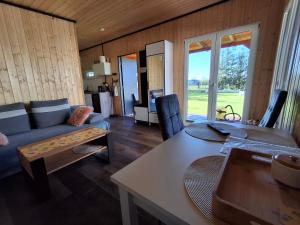 a living room with a couch and a table at Urlopownia-Domki z Indywidulanym Ogrodzeniem-Dogfriendly-Duży,Zielony Teren in Gąski