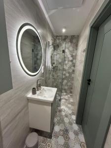 a bathroom with a sink and a shower and a mirror at Apartament Pastelowy in Głuszyca
