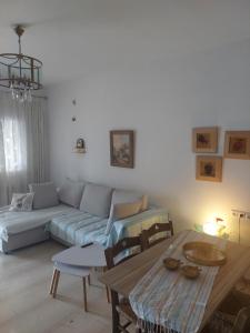 una sala de estar con un sofá y una mesa en Endless Blue Sea Frontal house, en Palaiokastro