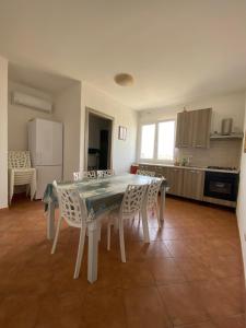 TriscinaにあるAPPARTAMENTO CON 3 CAMERE CON BAGNO INTERNO, CUCINA Sea & Sun 3の部屋にテーブルと椅子のあるキッチン