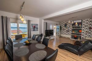 a living room with a dining room table and chairs at NOVOSELIC 7 Penthaus in Dramalj