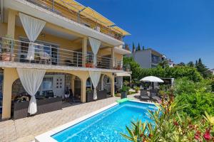a villa with a swimming pool in front of a house at NOVOSELIC 7 Penthaus in Dramalj