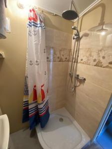 a bathroom with a shower and a toilet with a shower curtain at Bezvējš in Jūrmala