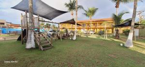 un resort con un parco giochi e un edificio con palme di Pousada Costa do Sol a Canavieiras