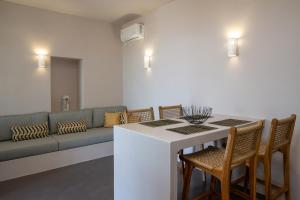 a living room with a couch and a table and chairs at Ohana suite Tinos in Arnados