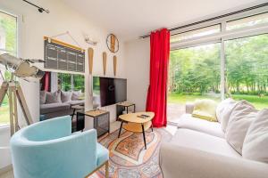 a living room with a white couch and a tv at Villa 200m2 cosy au calme avec baignoire balnéo in Saint-Ouen-les-Vignes