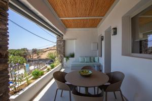 a room with a balcony with a table and chairs at Ohana suite Tinos in Arnados