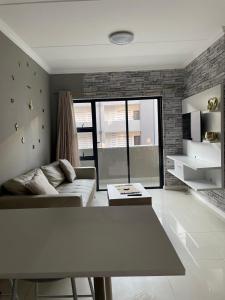 a living room with a couch and a table at 1 Bedroom Sleek, Spotless, Work-from-home Sanctuary in Midrand