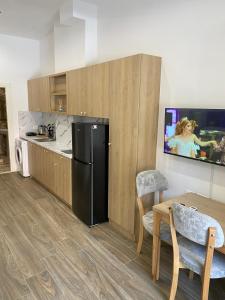 a kitchen with a black refrigerator and a table and chairs at DEJA BLUE Cozy Apartments in Durrës +38 photos