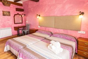 una camera con due letti e pareti rosa di Agroturismo "La Bardena Blanca II" ad Arguedas