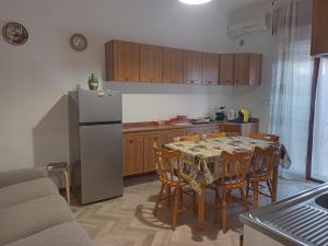 a kitchen with a table with chairs and a refrigerator at DiVenere Carbonara - Locazione Turistica in Bari